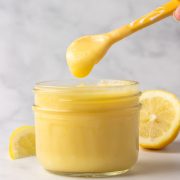 A jar of keto lemon curd with a spoon full of the curd.