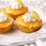 Three lemon supreme tarts with whipped cream.
