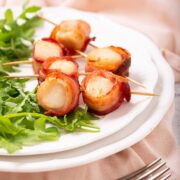 Bacon wrapped scallops on a bed of arugula
