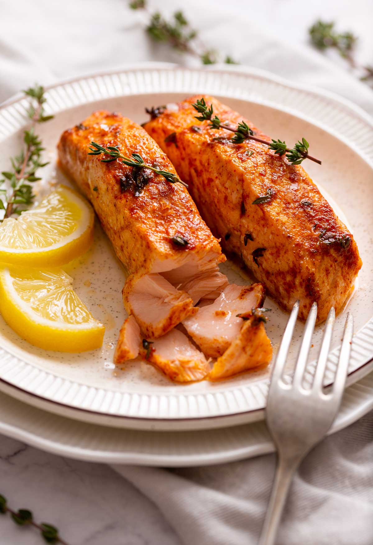 Serving the salmon on a plate with lemon slices.